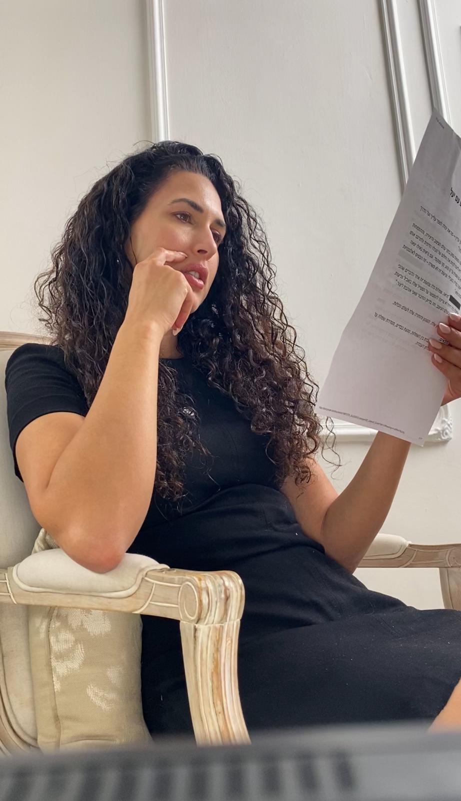 אישה בכיסא קריאייטיב מקריאה מסמך במהלך יום צילום